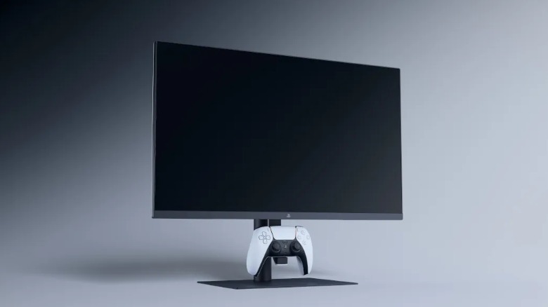 PlayStation's Wireless Fight Stick And New Gaming Monitor Arrive In August 1 A monitor with a DualSense controller resting on a hook underneath the screen